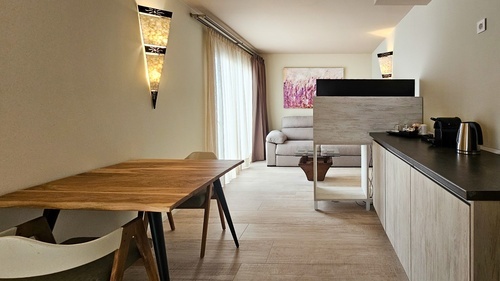 a kitchen with a table and chairs and a painting on the wall