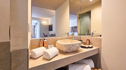 a bathroom with a stone sink and two bottles of lotion