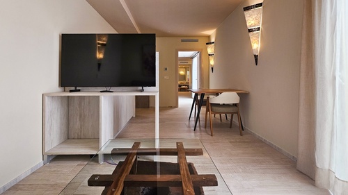 a living room with a table and chairs and a flat screen tv