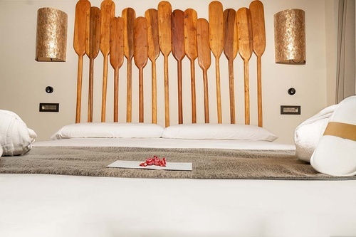 a bed with wooden oars on the wall behind it