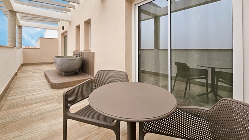 a table and chairs on a balcony with a bathtub in the background