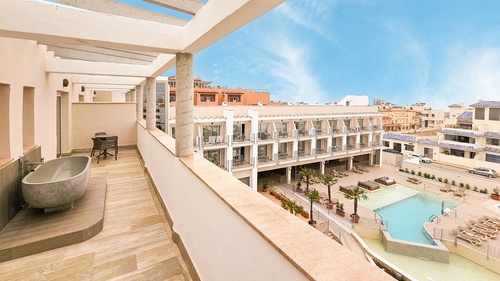 a balcony with a bathtub and a swimming pool