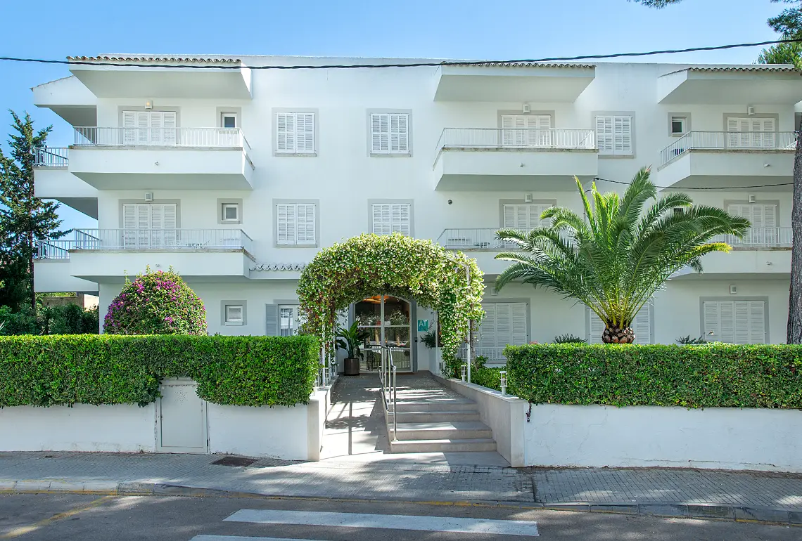 Hotel Exagon Park: terrassa d'un hotel amb balcons blancs i vegetació exuberant sota cel blau.