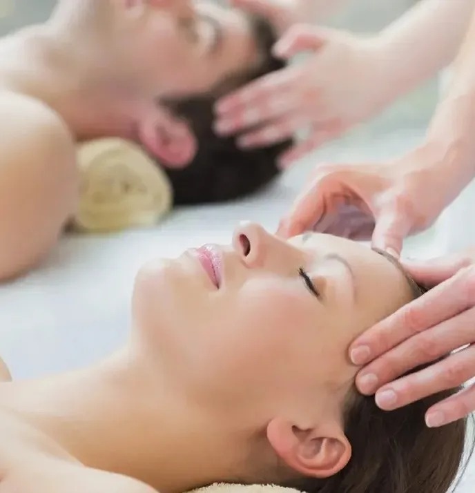 un hombre y una mujer reciben masajes en la cabeza en un spa