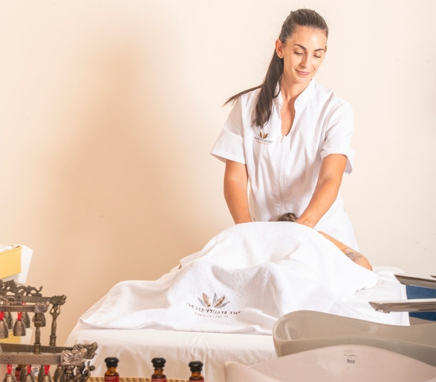 a woman is giving a massage with a white towel that says the bottle house