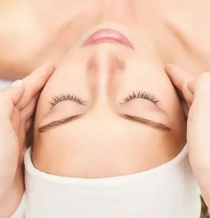 a woman is getting a head massage with her eyes closed