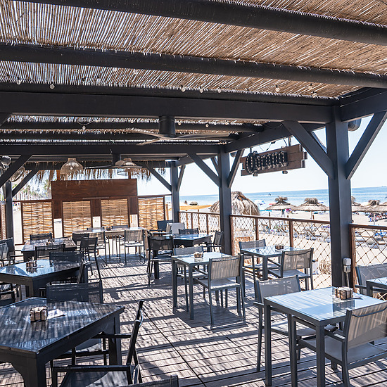 Terraza del Restaurante frente al hote con mesas y sillas frente al mar, ideal para FAY Hoteles: Corporativa.