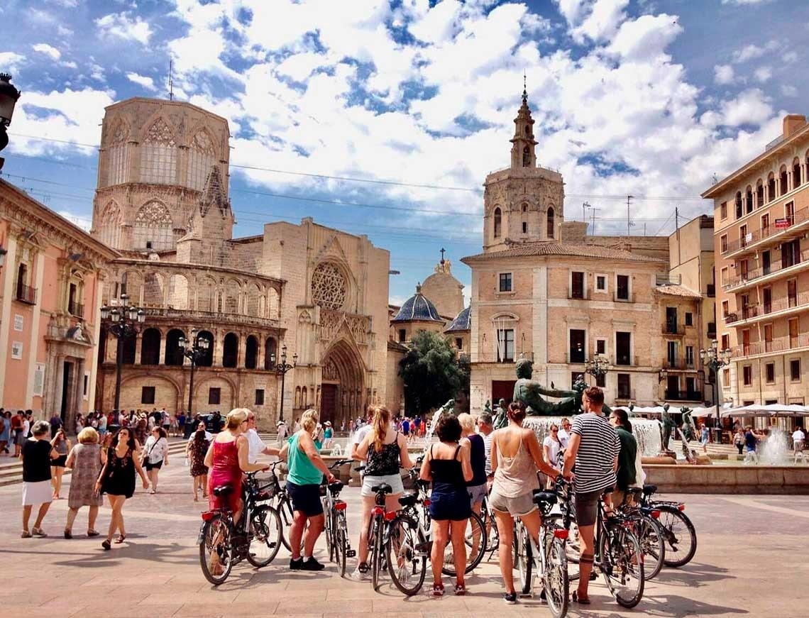 Plaza with cyclists and historic architecture. Perfect for feet up: corporate.