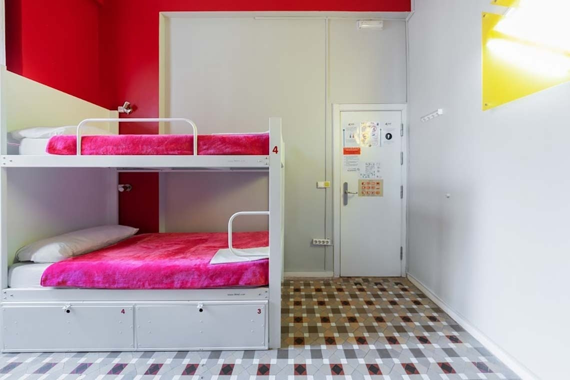 Bunk beds with pink blankets at Red Nest Hostel Valencia | Official website.