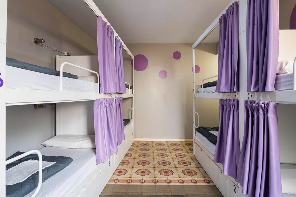 Bunk beds with purple curtains, ideal for corporate feet up stays.