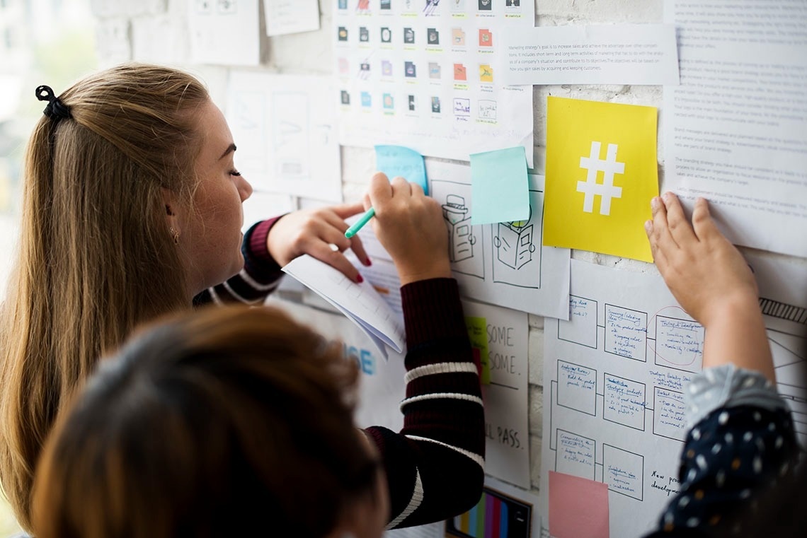 Tómese un respiro: equipo corporativo planificando en pared de ideas.