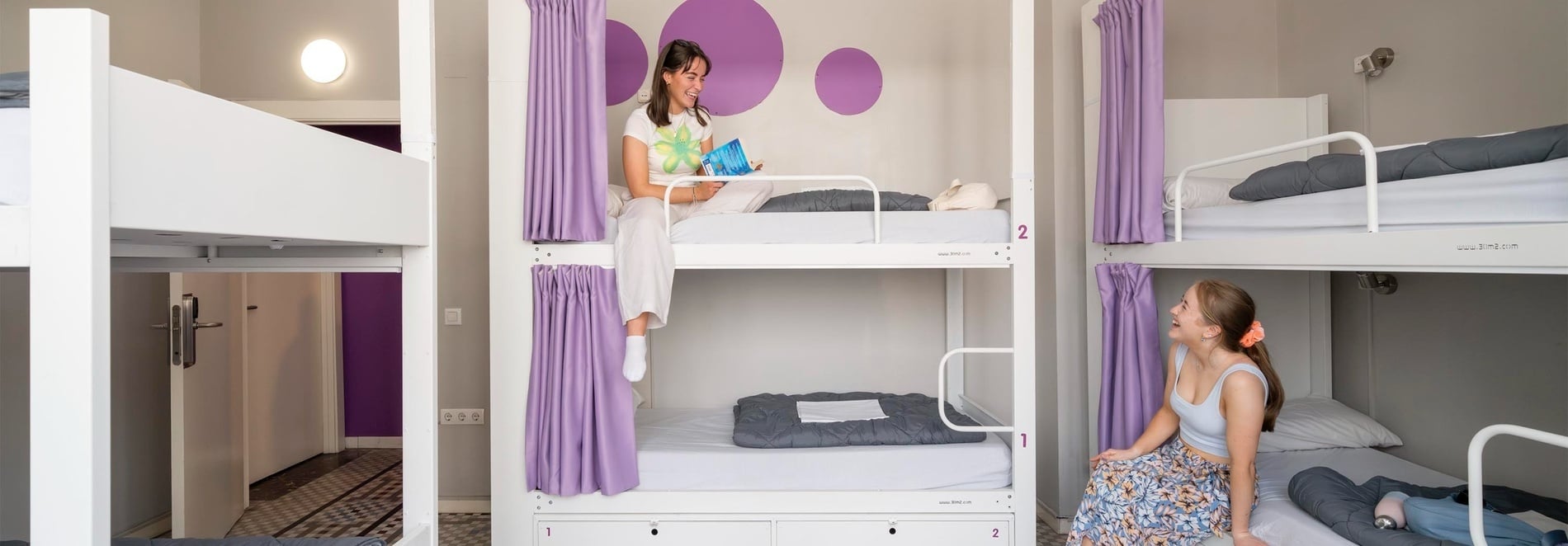 Bunk beds with purple curtains at Purple Nest Hostel Valencia | Feet Up | Valencia. Official website.