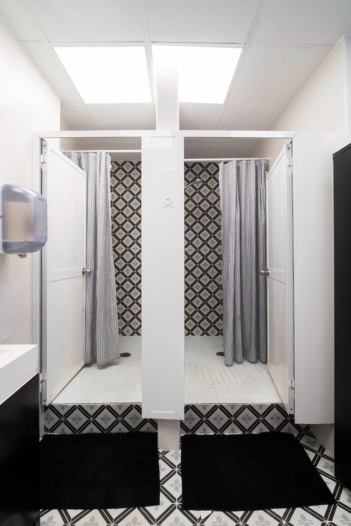 Shared shower stalls with patterned tiles at Hôme Youth Hostel Valencia | Feet Up.
