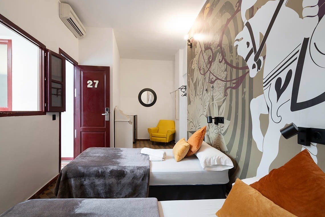 Room 27 at Hôme Youth Hostel Valencia with carousel horse mural. Book your stay on the official website.