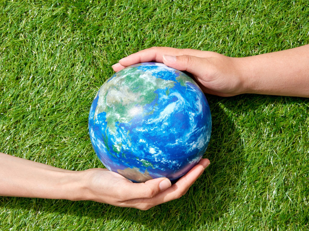 Manos cuidando la tierra, símbolo de un Feet up: Corporativa ecológico.
