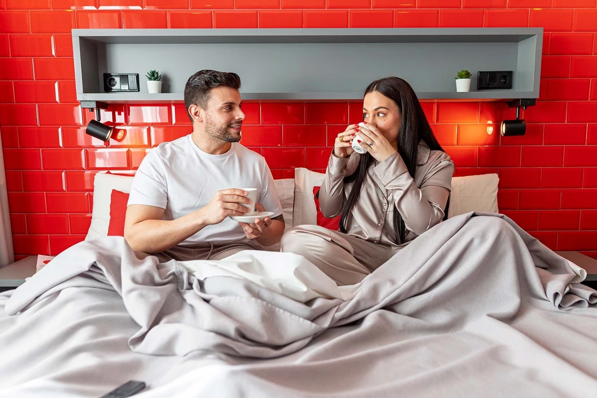 Pareja disfrutando café en la cama. ¡Pies arriba!: Corporativa