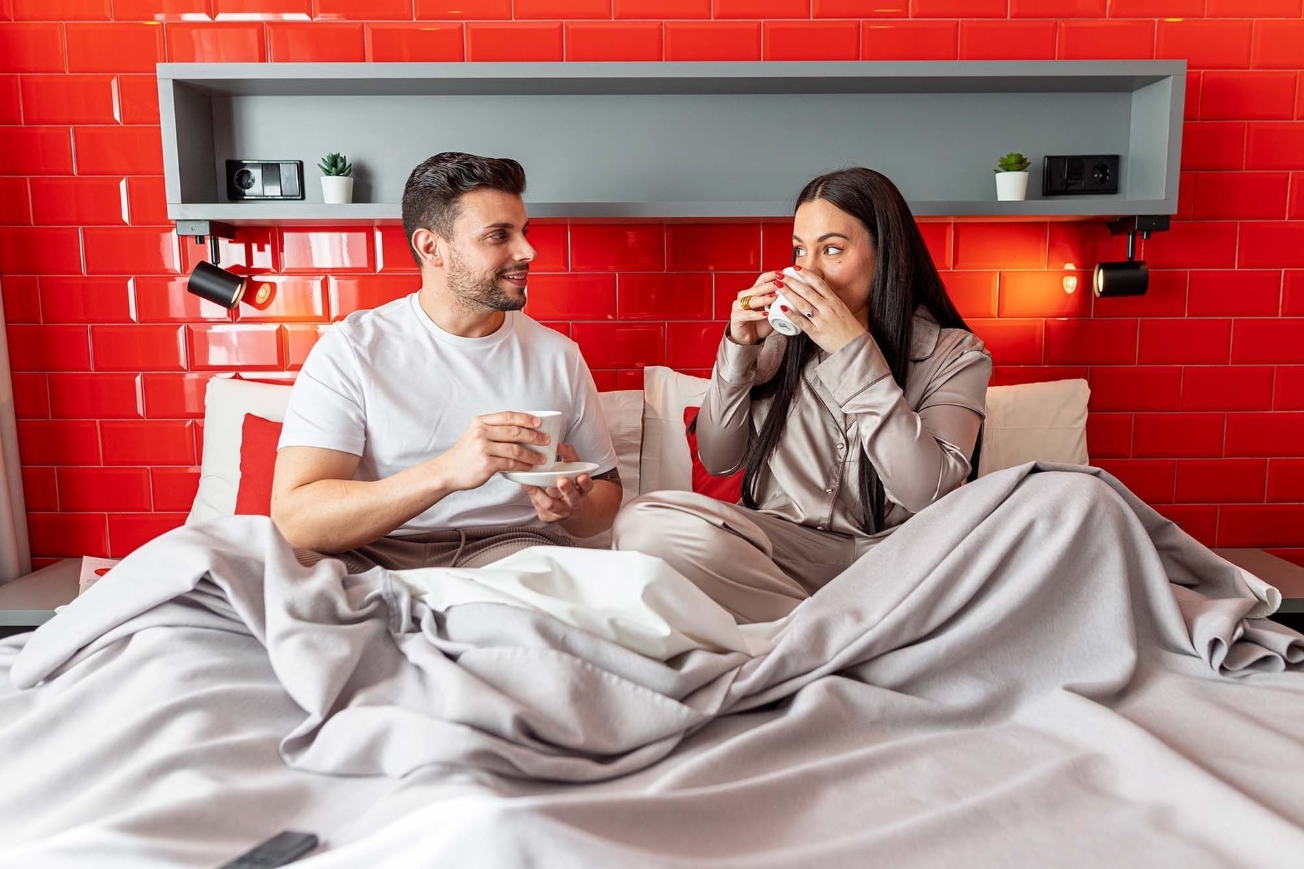 Couple enjoying coffee in bed. Feet up: Corporativa