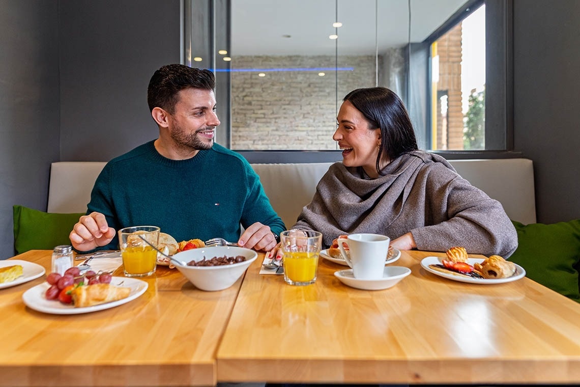 Pareja disfruta desayuno, un momento para relajarse. ¡Pies arriba: Corporativa!