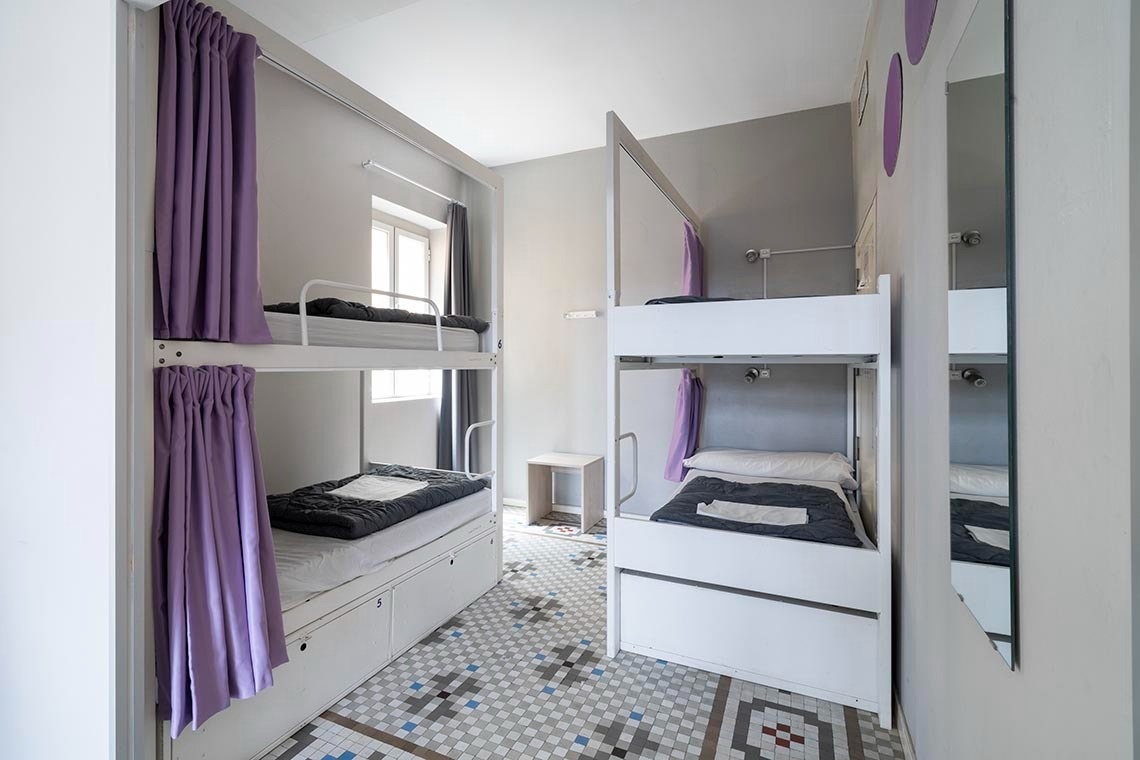 Bunk bed with purple curtains and foot space: Corporativa. Perfect for relaxation.