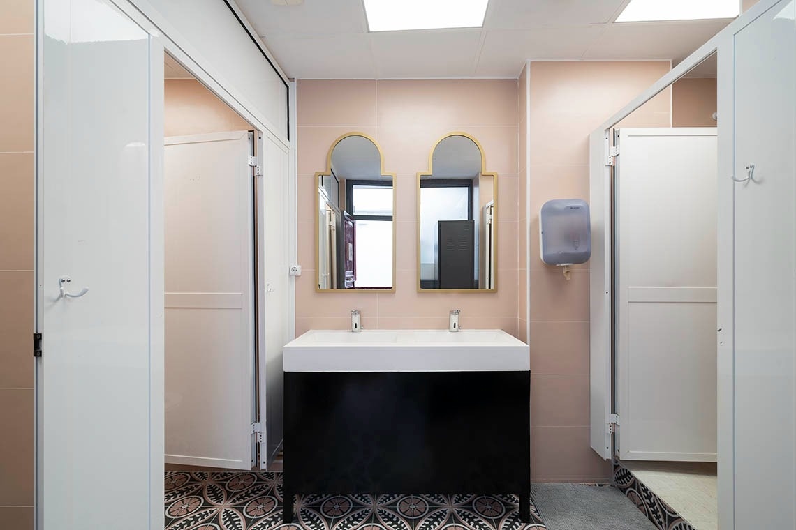 Modern bathroom with double sinks and white shower doors. Kick your feet up!
