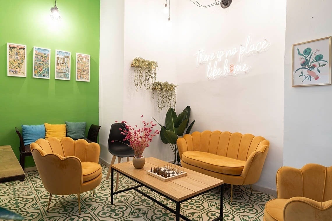 Cozy lounge at Hôme Youth Hostel Valencia with vintage seating and wall art.
