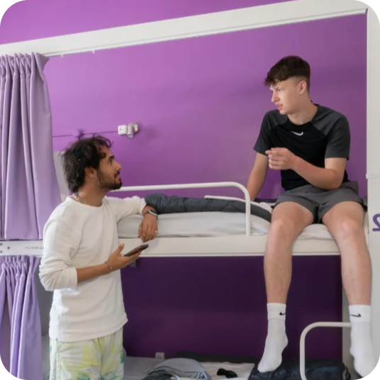 Young men relaxing on bunk beds, feet up: Fun corporate vibe.