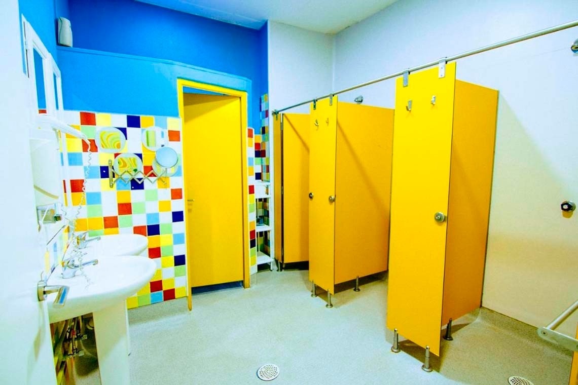 Colorful children's bathroom with showers and sinks, perfect for families.