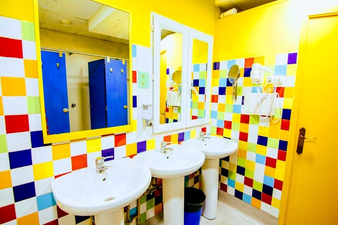 Colorful bathroom with sinks and shower doors. Feet up: Corporativa for your comfort!