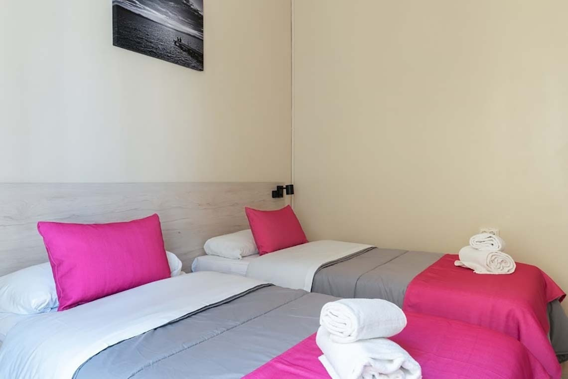 Twin beds with pink pillows at Red Nest Hostel Valencia | Feet Up | Valencia | Official website.