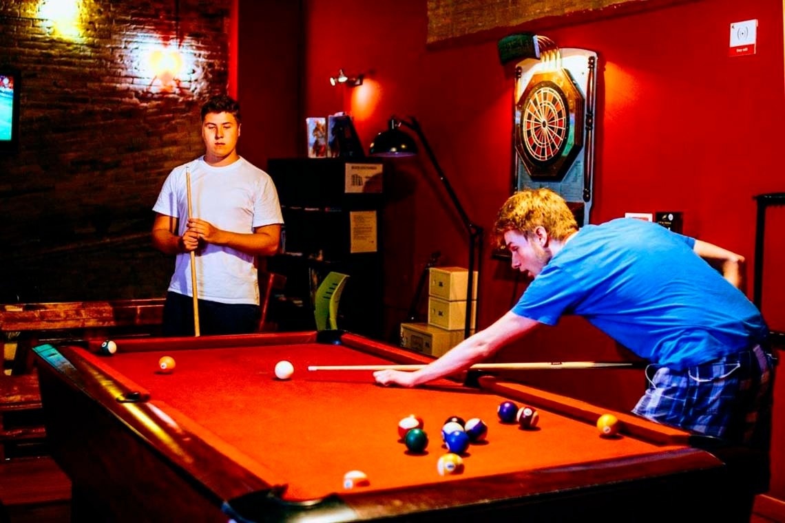 Men playing pool and darts, a great way to "feet up". Perfect for corporate events and relaxation.