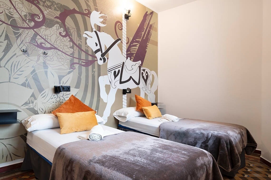 Twin beds with decorative carousel horse mural at Hôme Youth Hostel Valencia | Feet Up | Valencia | Official website