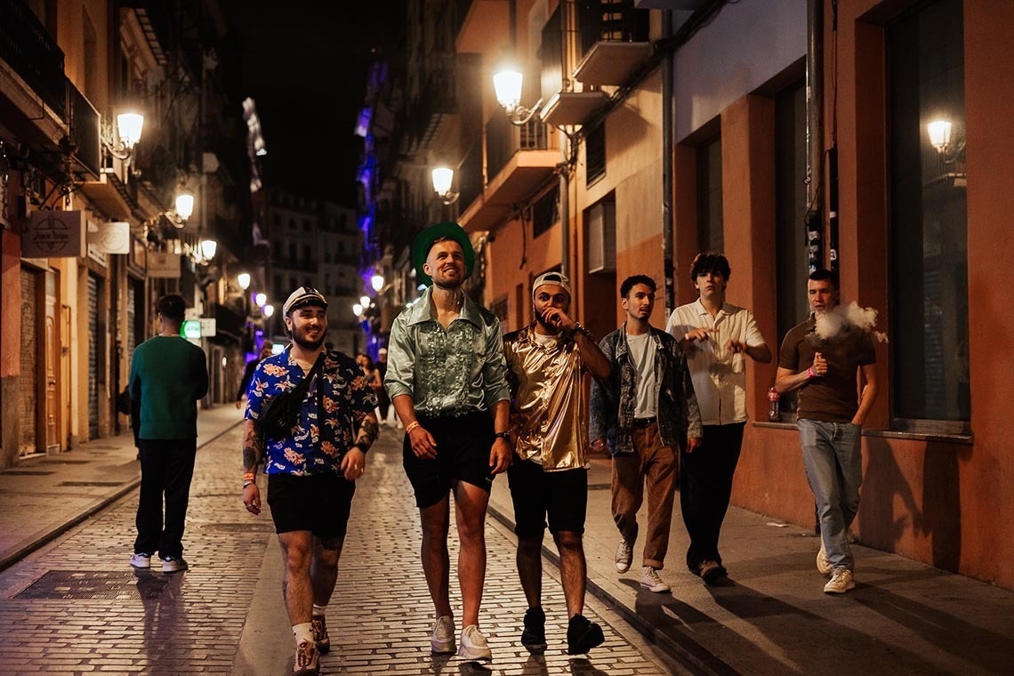 Friends walking on a street at night, ready for "Feet up: Corporativa".