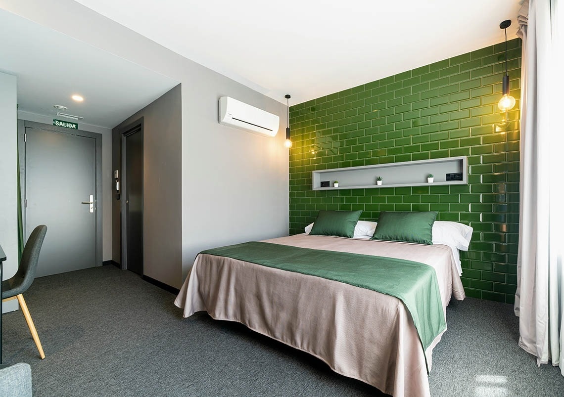 Cama cómoda en habitación de hotel moderno. Ideal para pies arriba: Corporativa.
