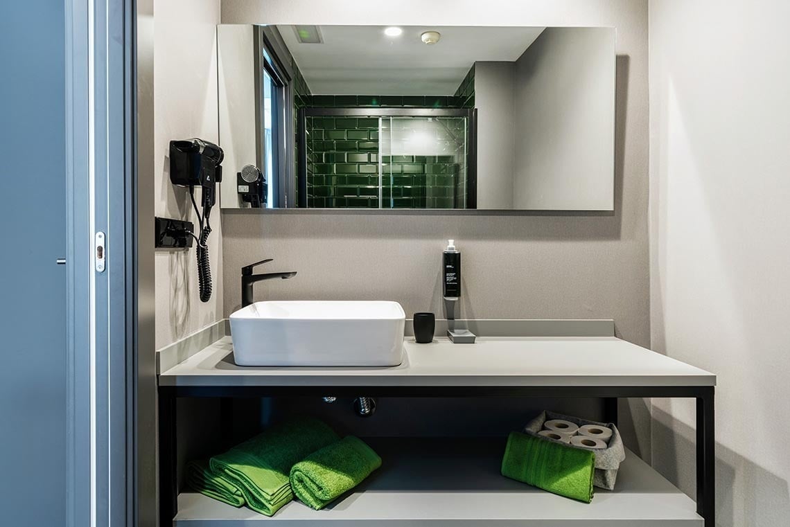 Lavabo moderno con secador de pelo y espejo en Nest Style Valencia Hotel | Web oficial