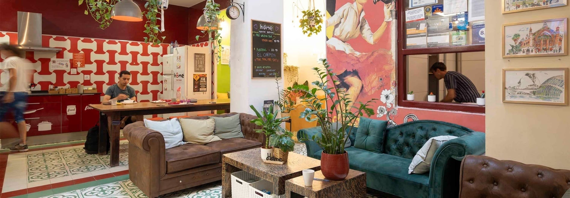 Hôme Youth Hostel Valencia: Cozy common area with sofas, plants, and art. Book your stay!