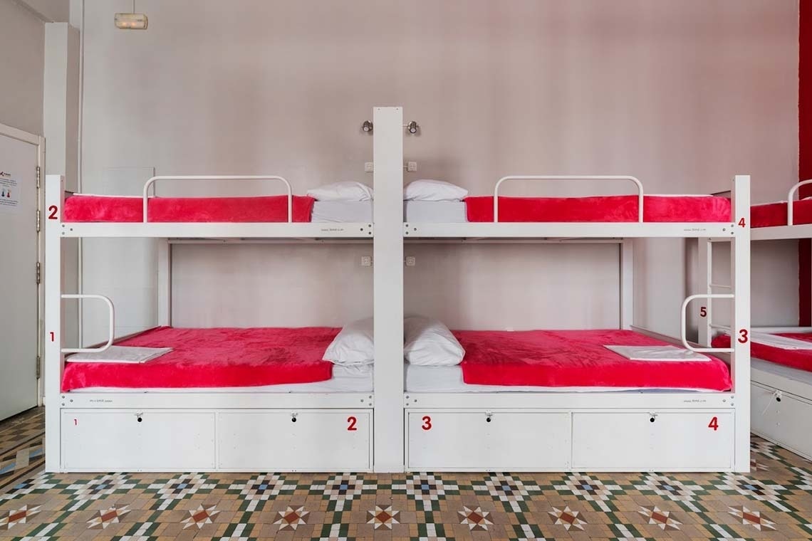 Bunk beds with red blankets and corporate foot space. Relax!
