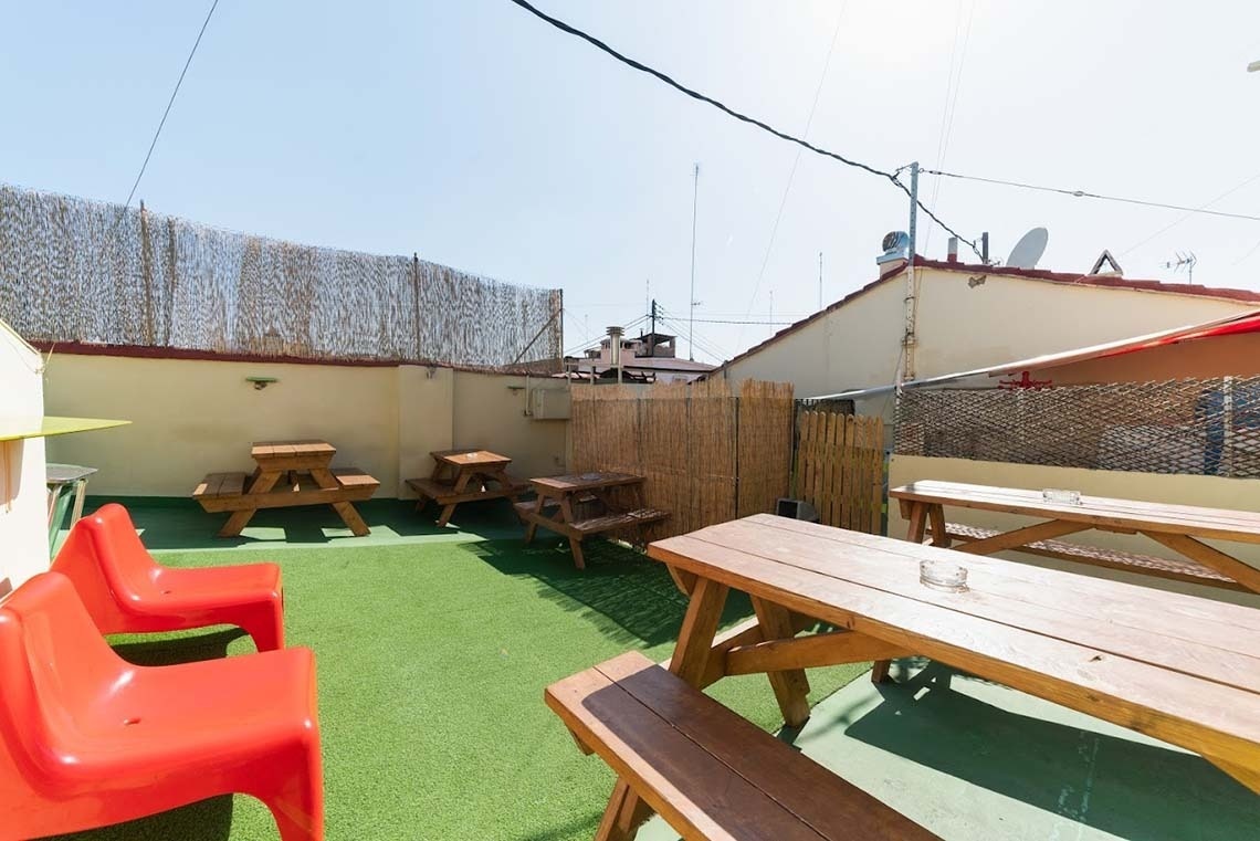 Hotel terrace with artificial turf, picnic tables, and red chairs. Feet up: Corporativa lounge area for relaxation.