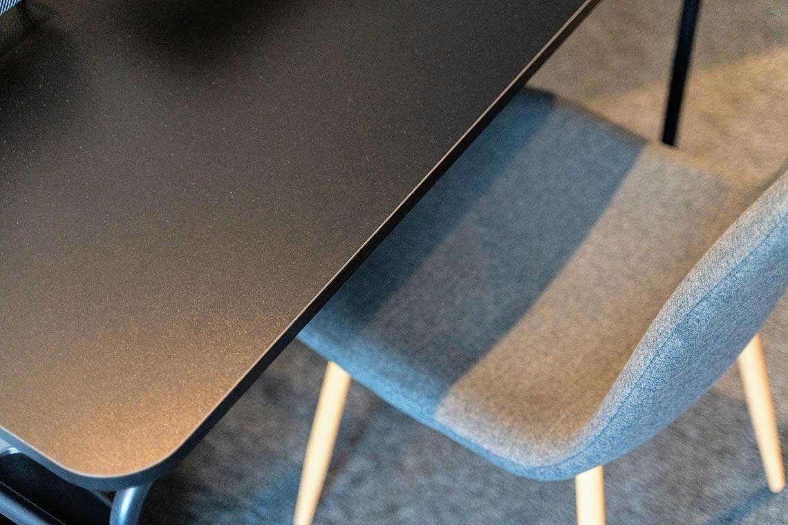 Mesa negra y silla tapizada azul en Nest Style Valencia Hotel | Piezas esenciales de la web oficial.