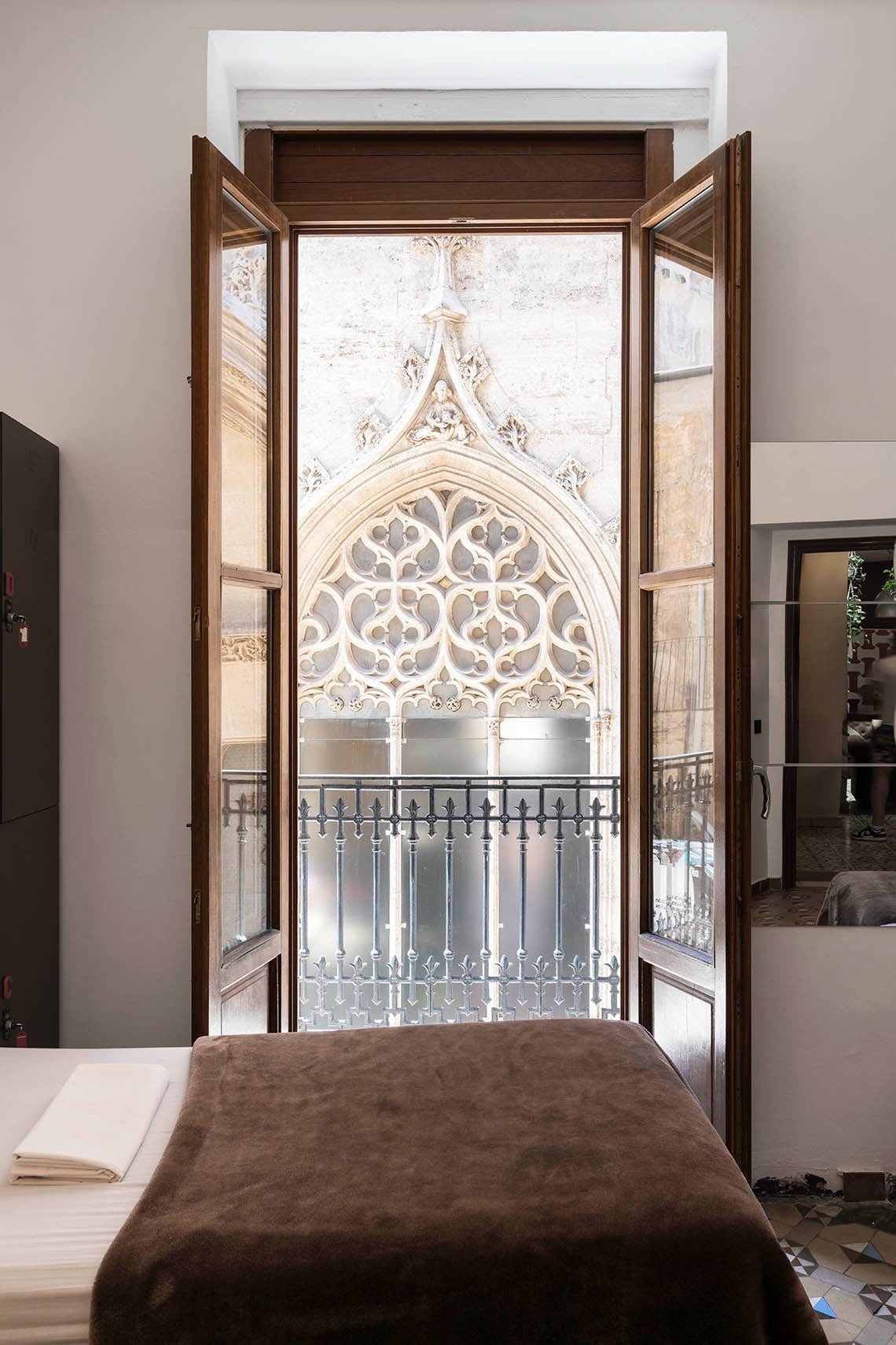 Guest room with a view of ornate gothic architecture at Hôme Youth Hostel Valencia. Official website.