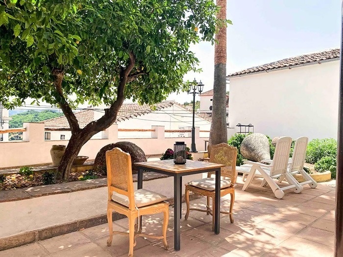 una mesa y sillas junto a un árbol en un patio