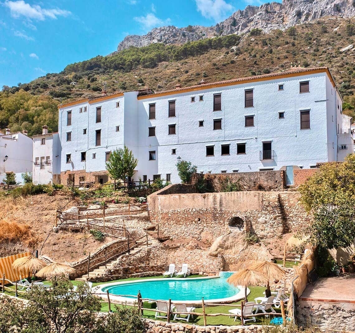 a large white building with a swimming pool in front of it