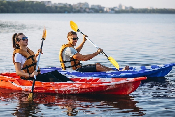 un hombre y una mujer están remando en kayaks en un lago