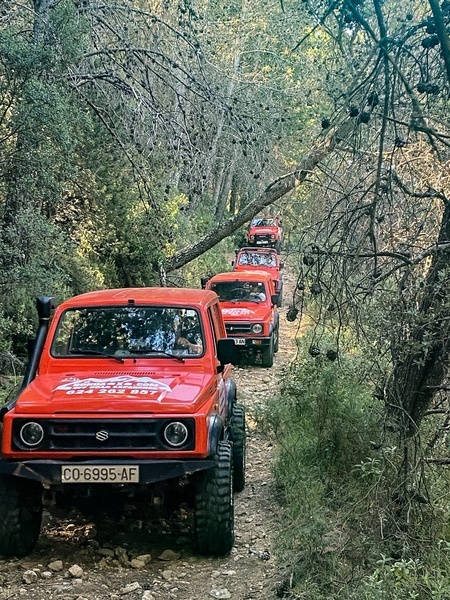 un jeep rosa conduce por un camino de tierra fangosa