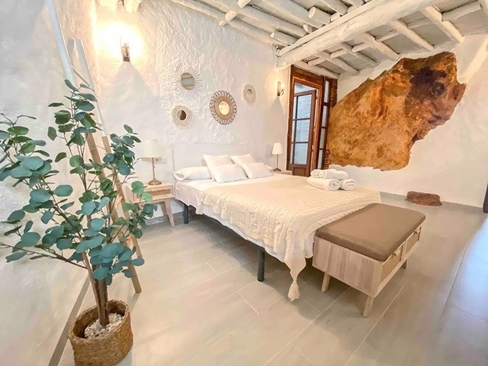 una habitación blanca con una cama y una planta