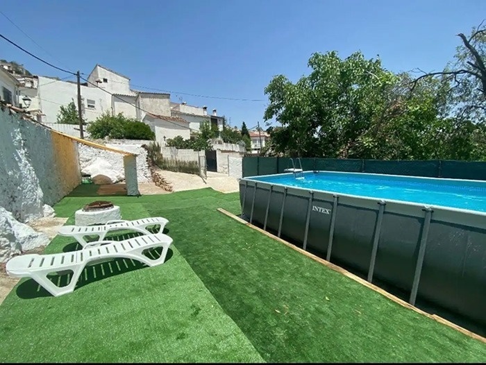 una piscina intex está en el patio trasero de una casa