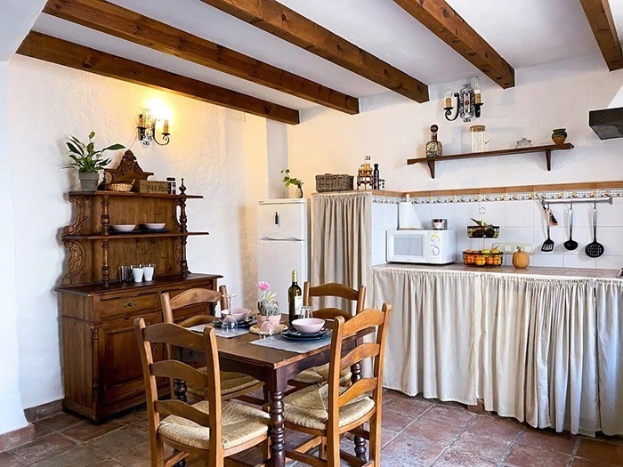 una cocina con una mesa y sillas y un refrigerador