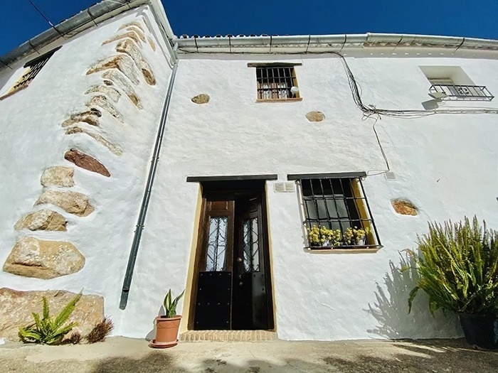 una casa blanca con una puerta negra y una ventana