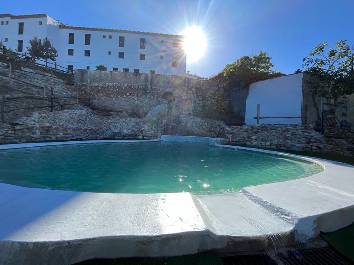 a large swimming pool with a white building in the background