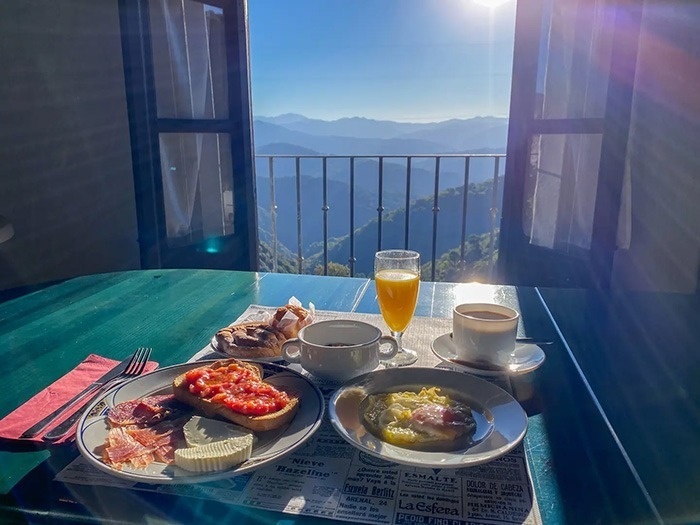 una mesa con platos de comida y un vaso de jugo de naranja