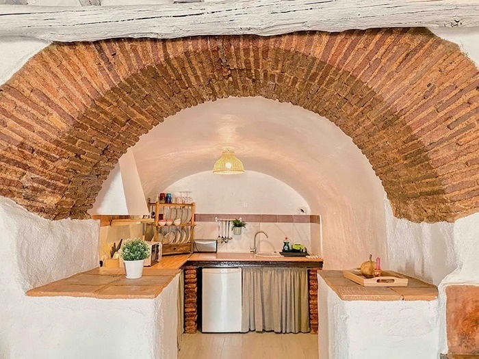 una cocina con una pared de ladrillo y un arco